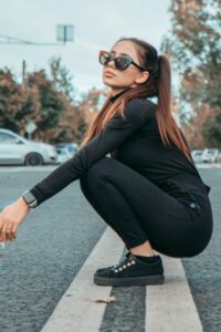 A slav Woman in a Black Outfit Squatting on a Road