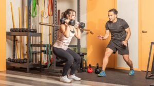 Athlete Woman Doing Squats with Dumbbells in Gym