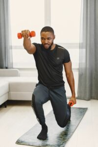 Home workout, closeup of athletic man doing lunges 