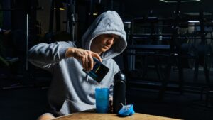 Man Pouring Energy Sports Supplement in Bottle ,