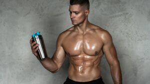 Muscular Man Drinking Whey Protein or Other Sport Supplement