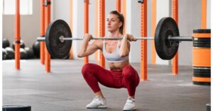Muscular weightlifter doing barbell front squat