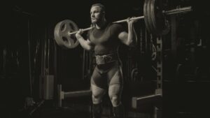 Professional athlete makes squats with a bar M,
