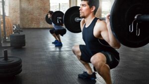 sportsman squatting while exercising at gym