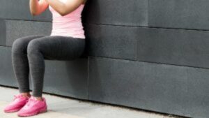 Athlete doing wall squat on city street