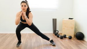 fitness-young-woman-doing-lateral-lunges-home-her-hiit-training-muscular-woman-sporty-clothing-working-out-home...
