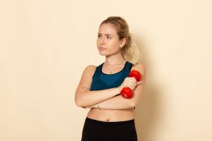 front-view-young-female-sport-outfit-holding-red-dumbbells-white-wall-health-sport-body-beauty-workout