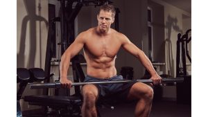 muscular-shirtless-athlete-doing-exercise-with-dumbbells-while-sits-bench-gym.j