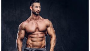 portrait-shirtless-tall-huge-male-with-muscular-body-with-stylish-haircut-beard-sports-shorts-posing-studio-isolated-dark-background.j