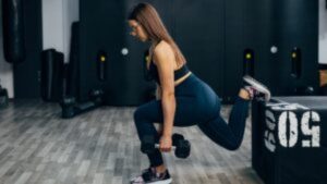 A woman who leads an active lifestyle trains in the gym doing the Bulgarian squat