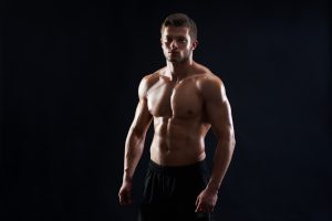 young-muscular-fit-sportsman-posing-shirtless-black-backgroun