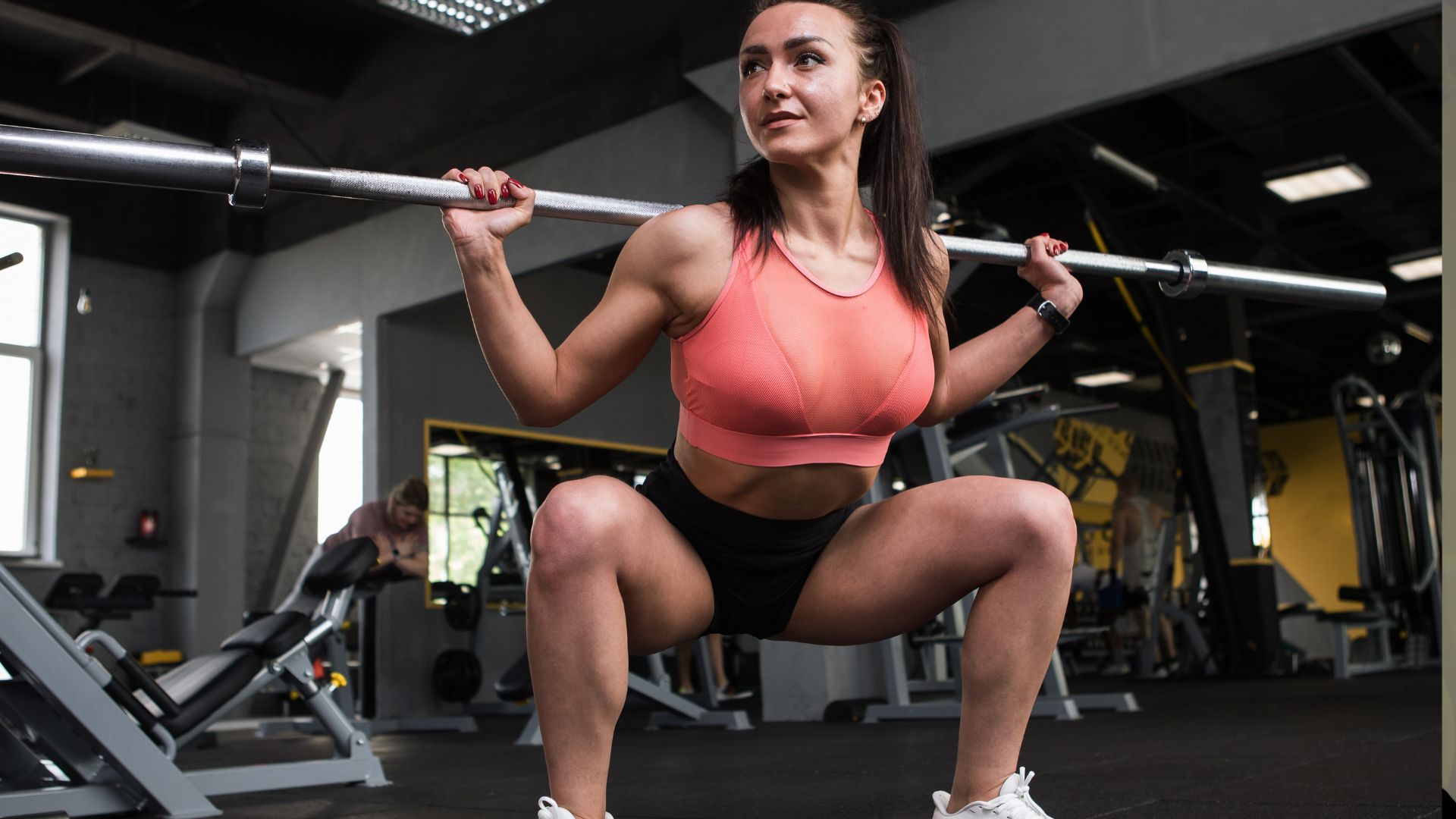 Low angle shot of a female bodybuilder exercising with barbell