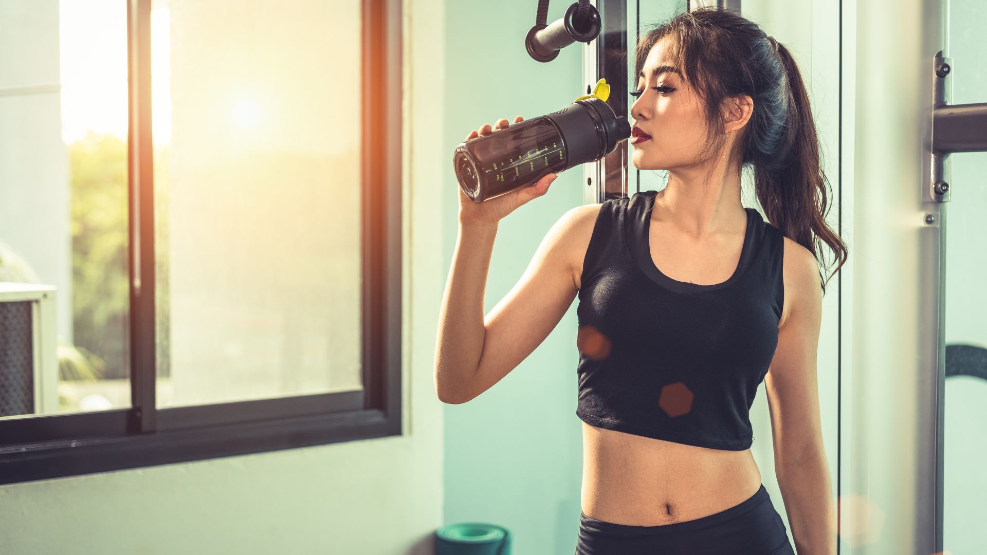 Asian Young Woman Drinking Protein Shake or Water after Exercise