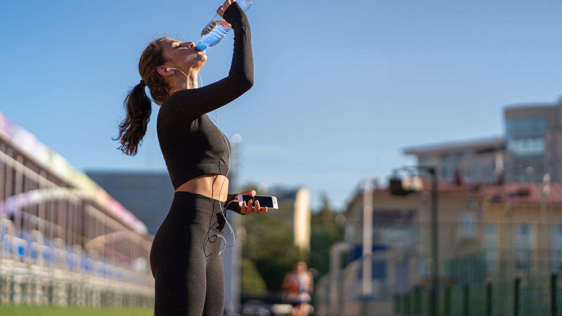 Fit Woman Drinking from Bottled Water after Workout