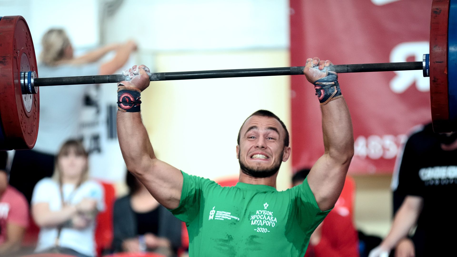 Man in Green Shirt Lifting Weights